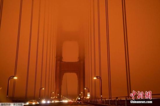 近日，大火所产生的烟雾遮盖住了整个旧金山湾区和北加州大部分地区的上空，使整片天空都变成了橘黄色。图为旧金山金门大桥几乎被烟雾遮蔽。