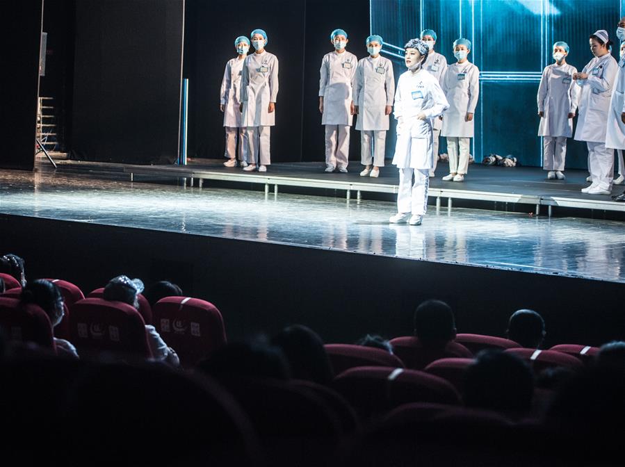 当日,抗疫题材话剧《逆行》在武汉中南剧场上演。来自武汉人民艺术剧院的演员们穿上防护服,换上白大褂,深情演绎出奋战在抗疫一线医务人员的感人故事。 新华社记者 肖艺九 摄