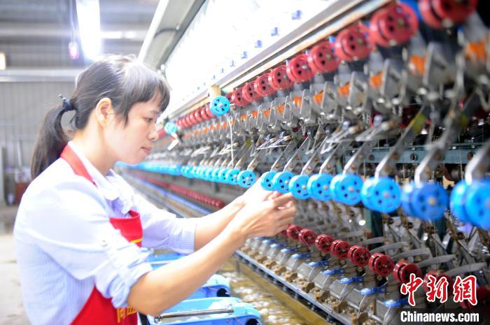 马玉兰在丝绸生产线上工作. 蒋雪林 摄