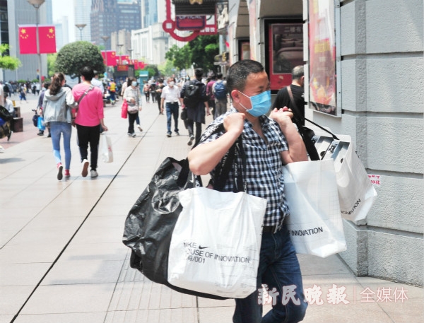 购物节"期间,在申城街头,随处可见提着大包小包的市民游客满载而归