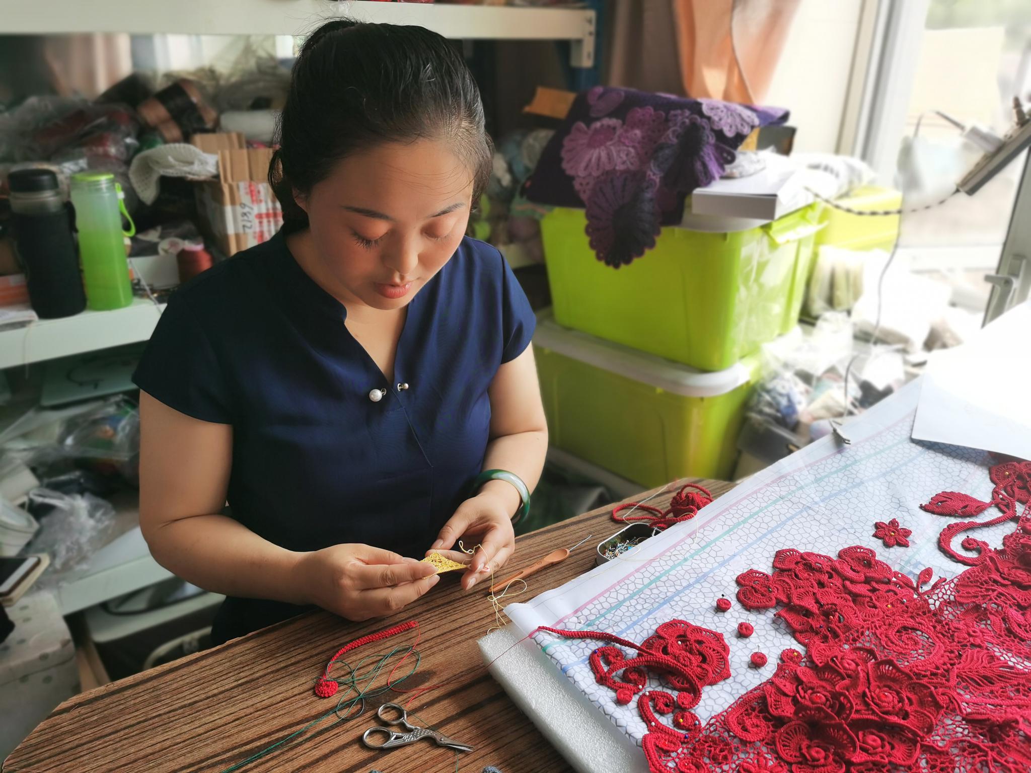 李明鸽正在黎明村的家中进行衣服编织.新华社记者 王君宝 摄