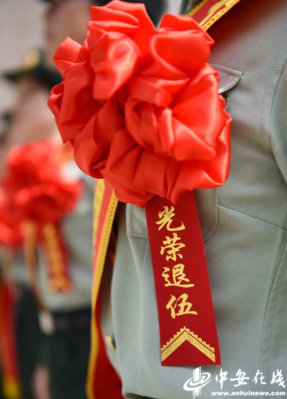 一位退伍女兵胸戴"光荣退伍"大红花