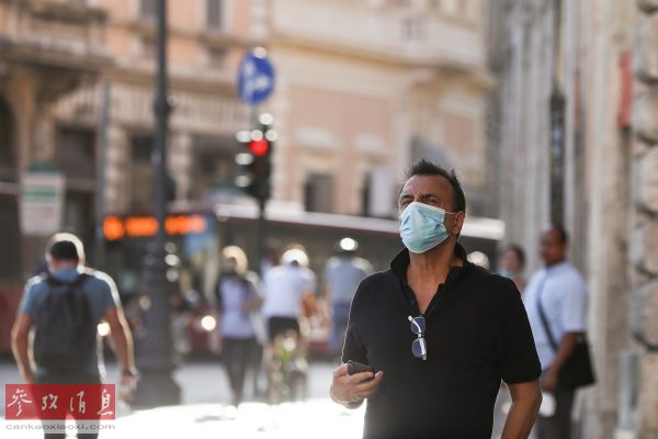 资料图片：8月4日，一名男子戴着口罩走在意大利首都罗马街头。（新华社记者 程婷婷 摄）