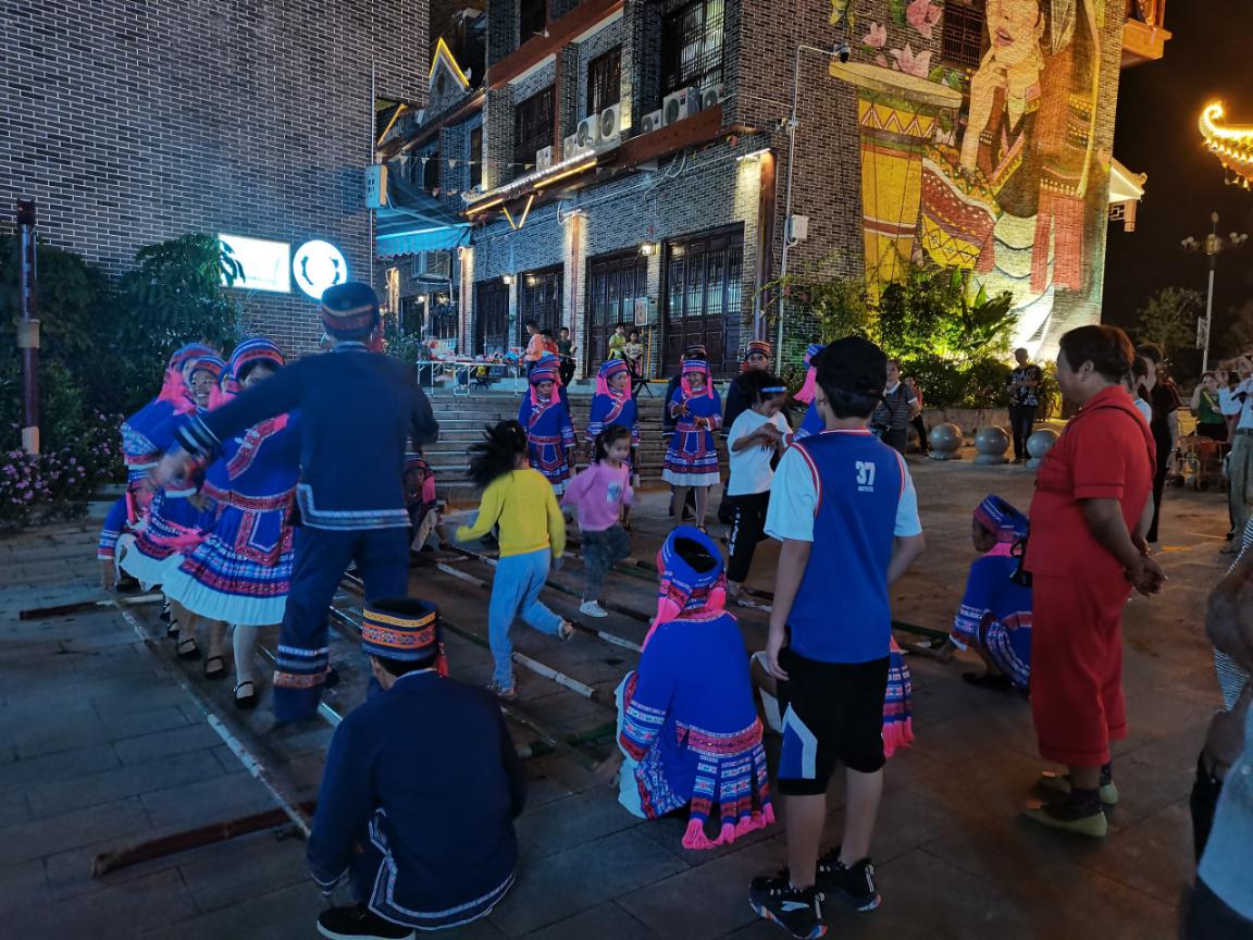 瑶族青年男女带着游客跳舞图/中国日报