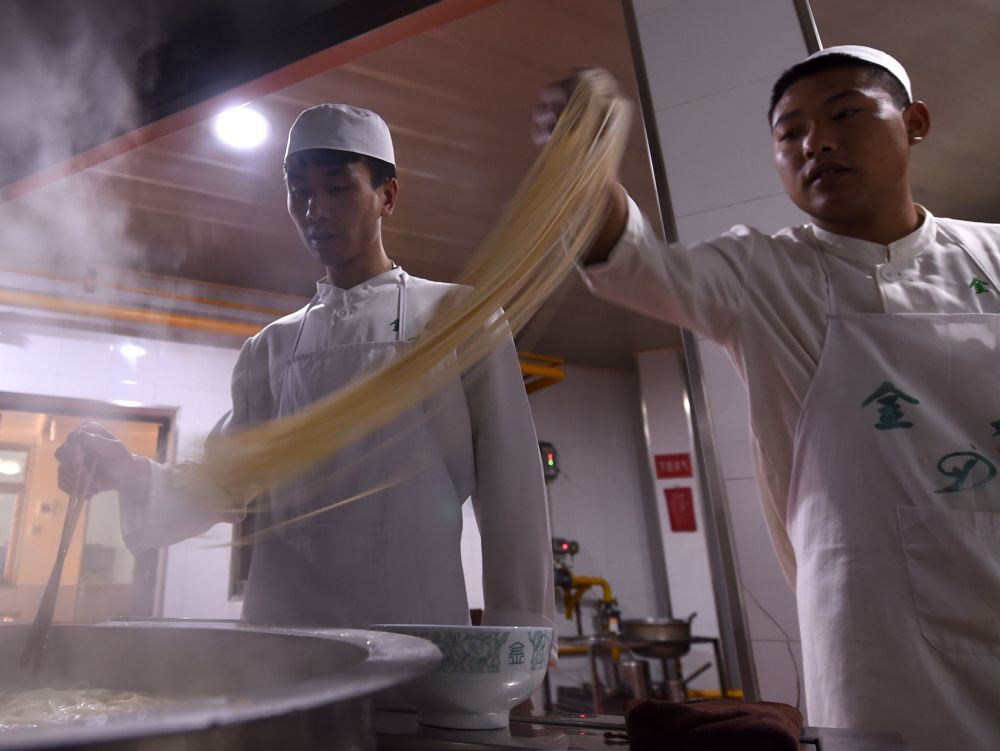 在兰州市一家牛肉面馆内,牛肉面师傅在煮面(4月2日摄).