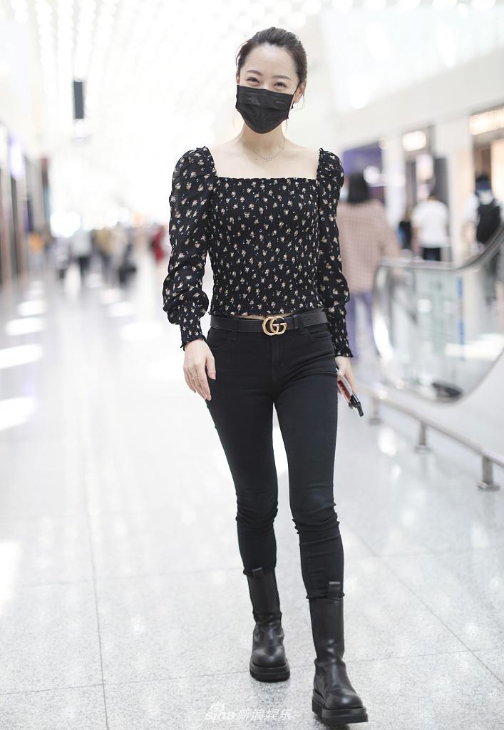 扎着丸子头的她身着碎花上衣和紧身牛仔裤,搭马丁靴秀纤细美腿,见跟拍