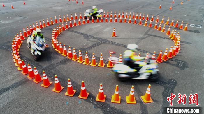 图为骑手驾驶摩托车通过反光锥摆放成的环岛赛道.郑州市交警支队供图