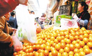 在篆新农贸市场，水果商贩为购物市民提供塑料袋。记者 黄晓松 摄