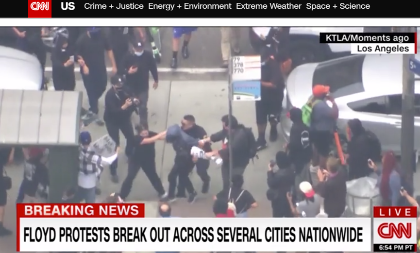 （图为游行期间美国警察与抗议者发生冲突，一名警察遭到多名抗议者袭击的画面，截图来自CNN）