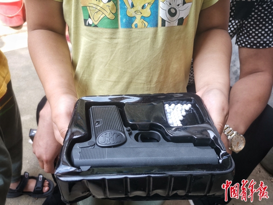 9月12日，山东省临沂市，景安朋的儿子捧着父亲留下的玩具枪。本版照片均为中青报·中青网记者 耿学清/摄