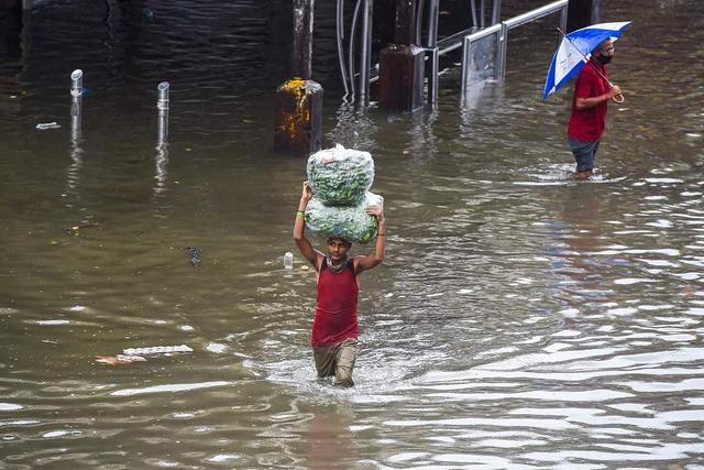 印度孟买迎来降雨民众趟水出行