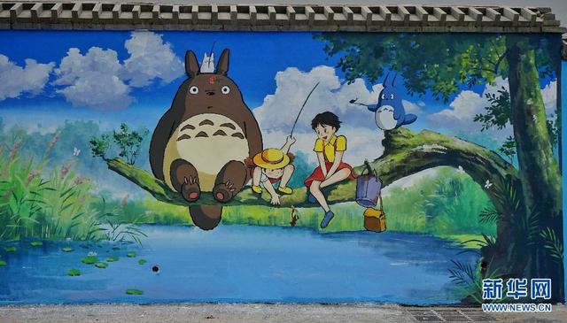 新华网发(董志刚 摄)游人在和《千与千寻》墙绘合照.