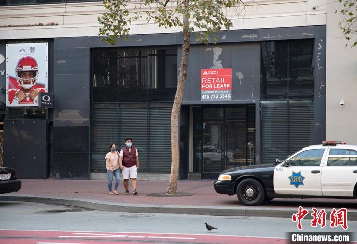 当地时间9月5日，美国加州旧金山市民从一家关闭的商店门口经过。旧金山当地媒体援引美国点评网站的资料称，自新冠肺炎疫情暴发以来，湾区已有超过2000家企业永久关闭。 中新社记者 刘关关 摄