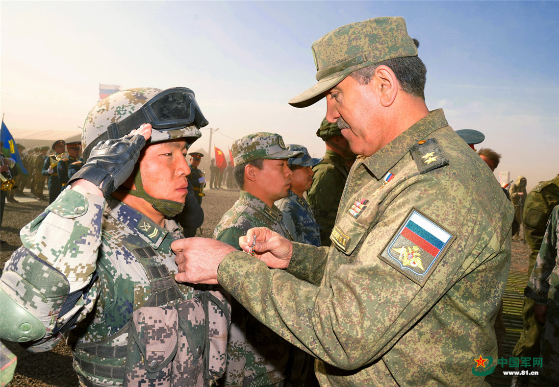 俄罗斯国防部副部长叶夫库罗夫中将向中方参演官兵颁发勋章。