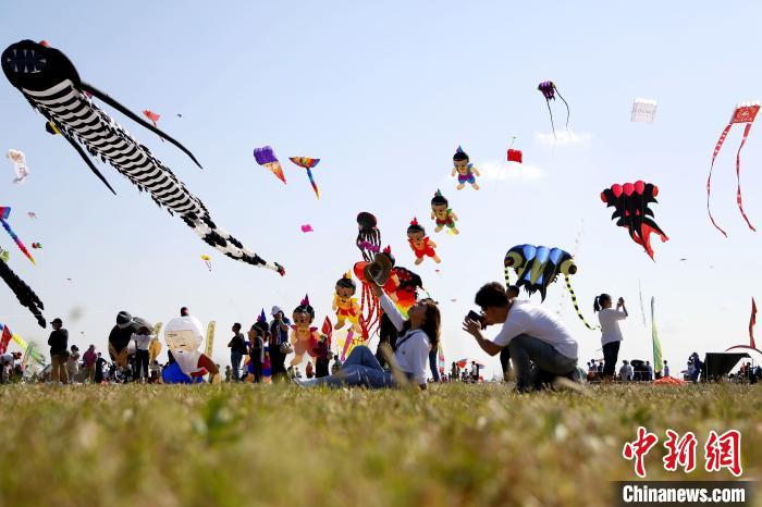 在第37届潍坊国际风筝会开幕当天，各地游客前来欣赏风筝放飞风采，拍照留念。　沙见龙 摄