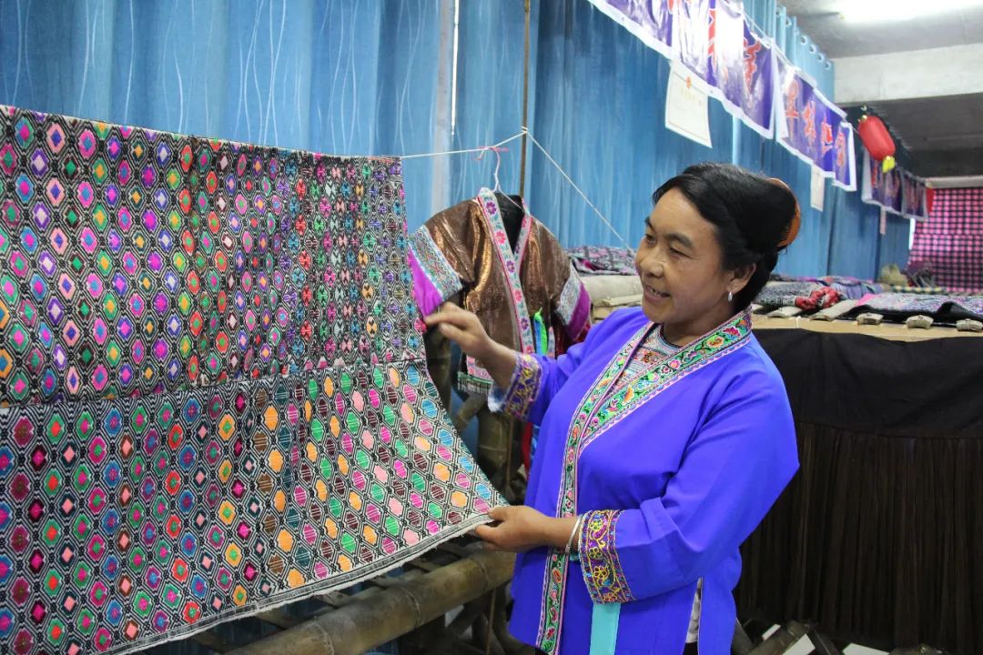 户村民提供销售平台,图为贾佩仙在介绍她手工织的苗锦织苗锦"她好能干