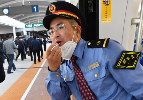 开车前列车长吹哨示意准备开车.摄影/新京报记者&nbsp;吴宁