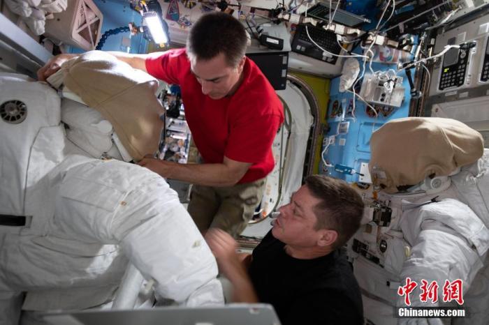 资料图：2020年6月24日报道，美国宇航员克里斯托弗·卡西迪（左）和罗伯特·本肯将于6月26日和7月1日从国际空间站出发进行两次太空行走，以便更换电池。图为二人在准备太空服。图片来源：视觉中国