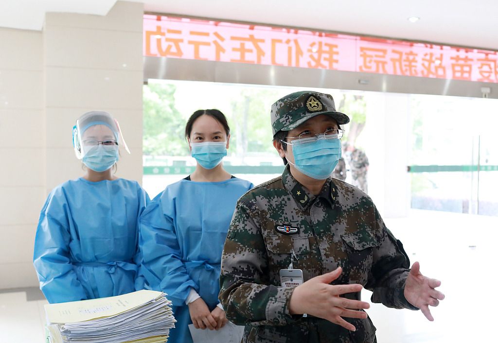 2020年5月13日，陈薇（右）在武汉东湖疗养中心和研究人员交流重组新冠病毒疫苗Ⅱ期临床试验工作。图片来源/视觉中国