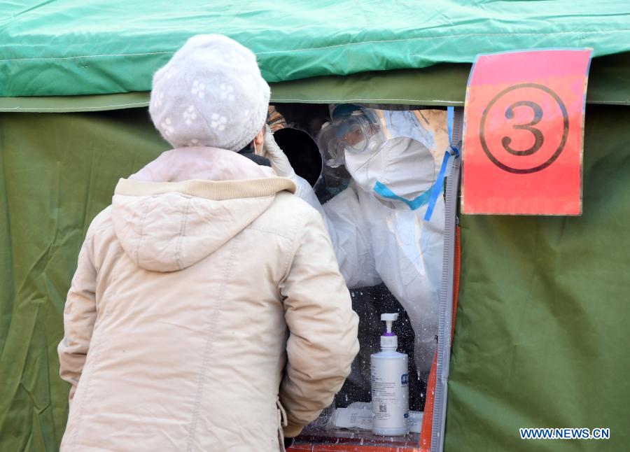 A medical worker (R) collects nucleic acid test samples at Xiangyue West sampling site in Shunyi District of Beijing, capital of China, Jan. 3, 2021. Beijing reported one new locally transmitted confirmed COVID-19 case and one imported case on Saturday, local health authorities said Sunday. Recently, a second nucleic acid testing has been conducted at Xiangyue West community in Shunyi District. (Xinhua/Ren Chao)
