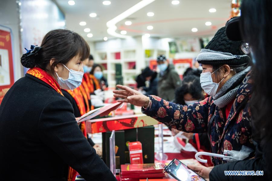 People buy the newly issued special stamps themed on the Year of the Ox at a post office in Guiyang, southwest China's Guizhou Province, Jan. 5, 2021. China Post on Tuesday issued a set of two special stamps to mark the upcoming Year of the Ox. (Xinhua/Tao Liang)