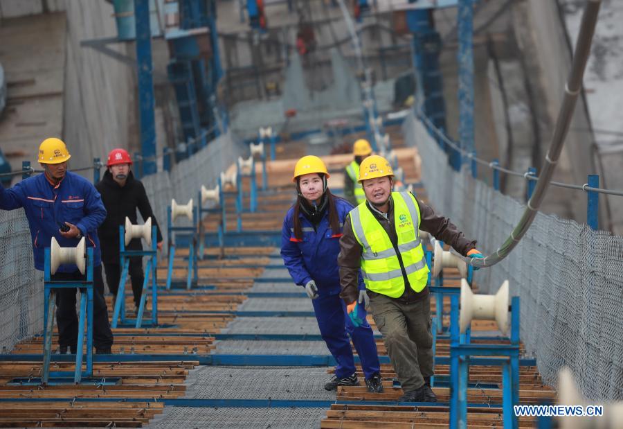 Workers install the main cables on the Kaizhou Lake grand bridge in southwest China's Guizhou Province, Jan. 5, 2021. The Kaizhou Lake grand bridge is part of the Weng'an-Kaiyang expressway. With a main span of 1,100 meters, the bridge is 1,257 meters in length and one of its main towers is 139 meters in height. (Xinhua/Liu Xu)