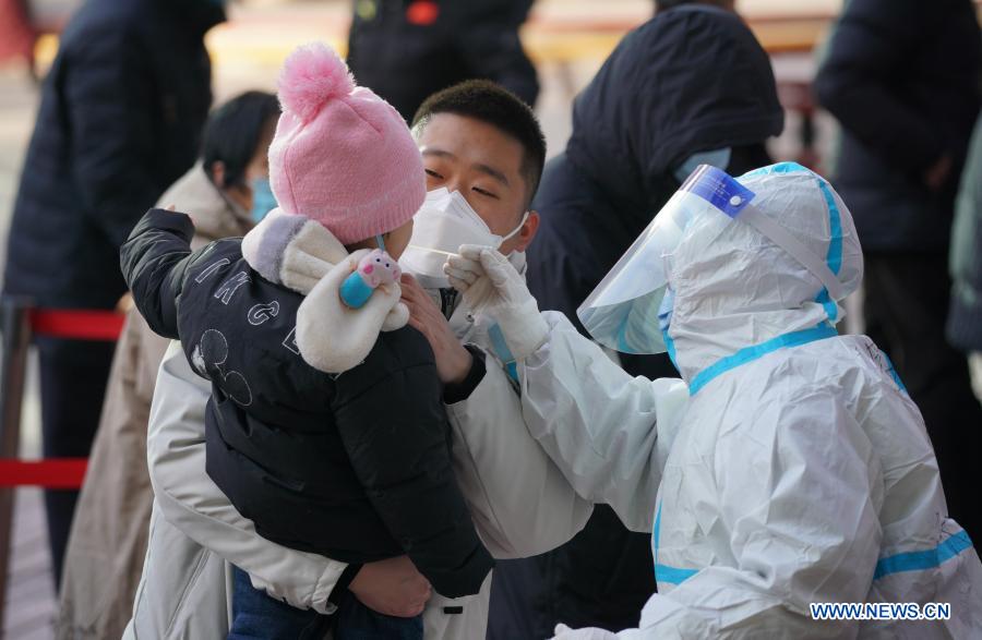 A medical worker collects a swab sample from a girl at a community in Qiaoxi District of Shijiazhuang, capital of north China's Hebei Province, Jan. 6, 2021. Shijiazhuang started to conduct citywide nucleic acid tests covering all citizens on Wednesday. (Xinhua/Mu Yu)