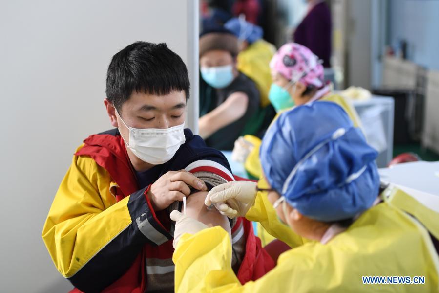 A medical worker administers a shot of the COVID-19 vaccine to a delivery man at a temporary vaccination site in Haidian District of Beijing, capital of China, Jan. 6, 2021. (Xinhua/Ju Huanzong)