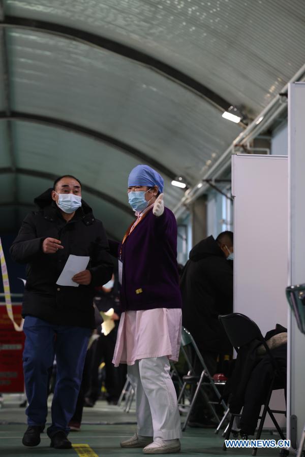 A medical worker guides people who come for the COVID-19 vaccination at a temporary vaccination site in Haidian District of Beijing, capital of China, Jan. 6, 2021. (Xinhua/Lu Ye)