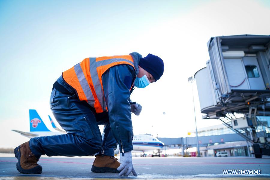 Guo Xin, leader of the aircraft maintenance team of Daqing Saertu Airport, works at the airport in Daqing, northeast China's Heilongjiang Province, Jan. 8, 2021. To ensure the smooth and safe operation of the airport, aircraft maintenance engineers here worked hard despite the low temperature of about minus 30 degrees Celsius. (Xinhua/Wang Song)