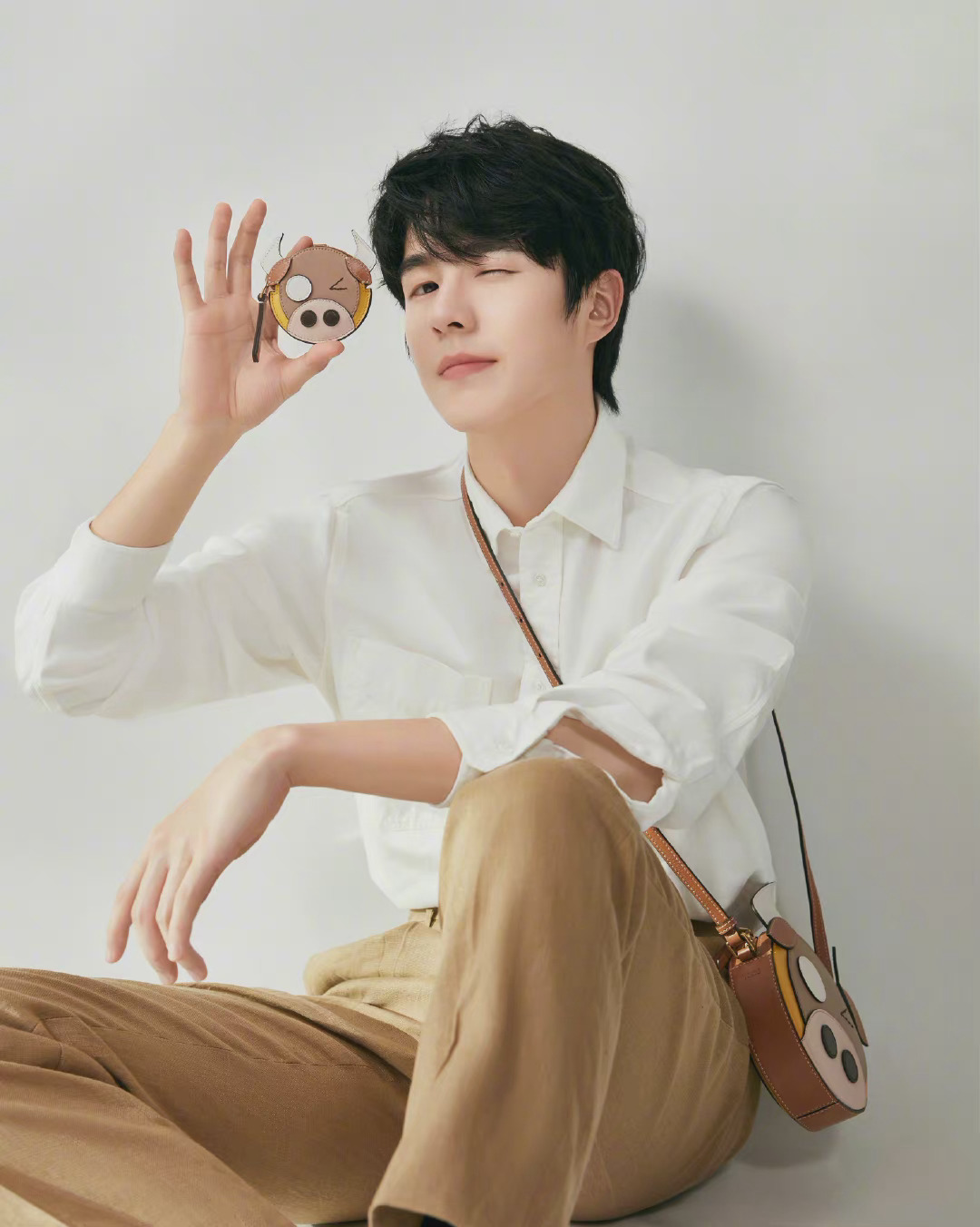 刘昊然身穿简约白衬衫,搭配可爱小挎包,清爽干净的俏皮男孩