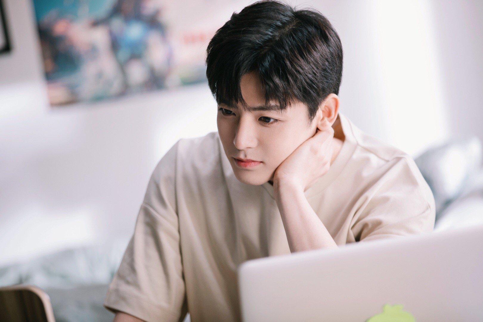 侯明昊穿棕色格纹大余搭配米棕色t恤,清爽又不失稳重