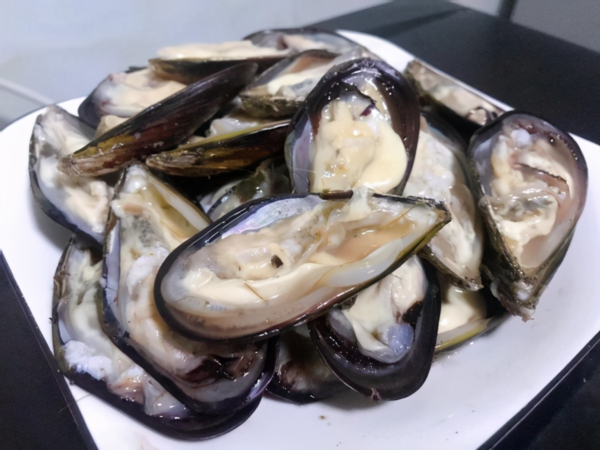 3,烤盘上铺上一层锡纸,然后将所有的贻贝全部处理好之后摆放在烤盘