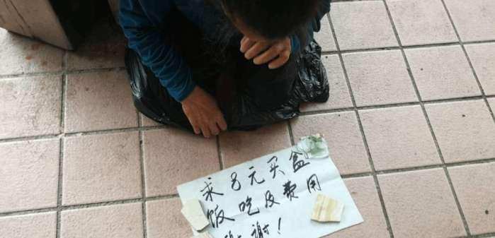 女子街头乞讨纸牌上写着求8元买盒饭,却无人问津!