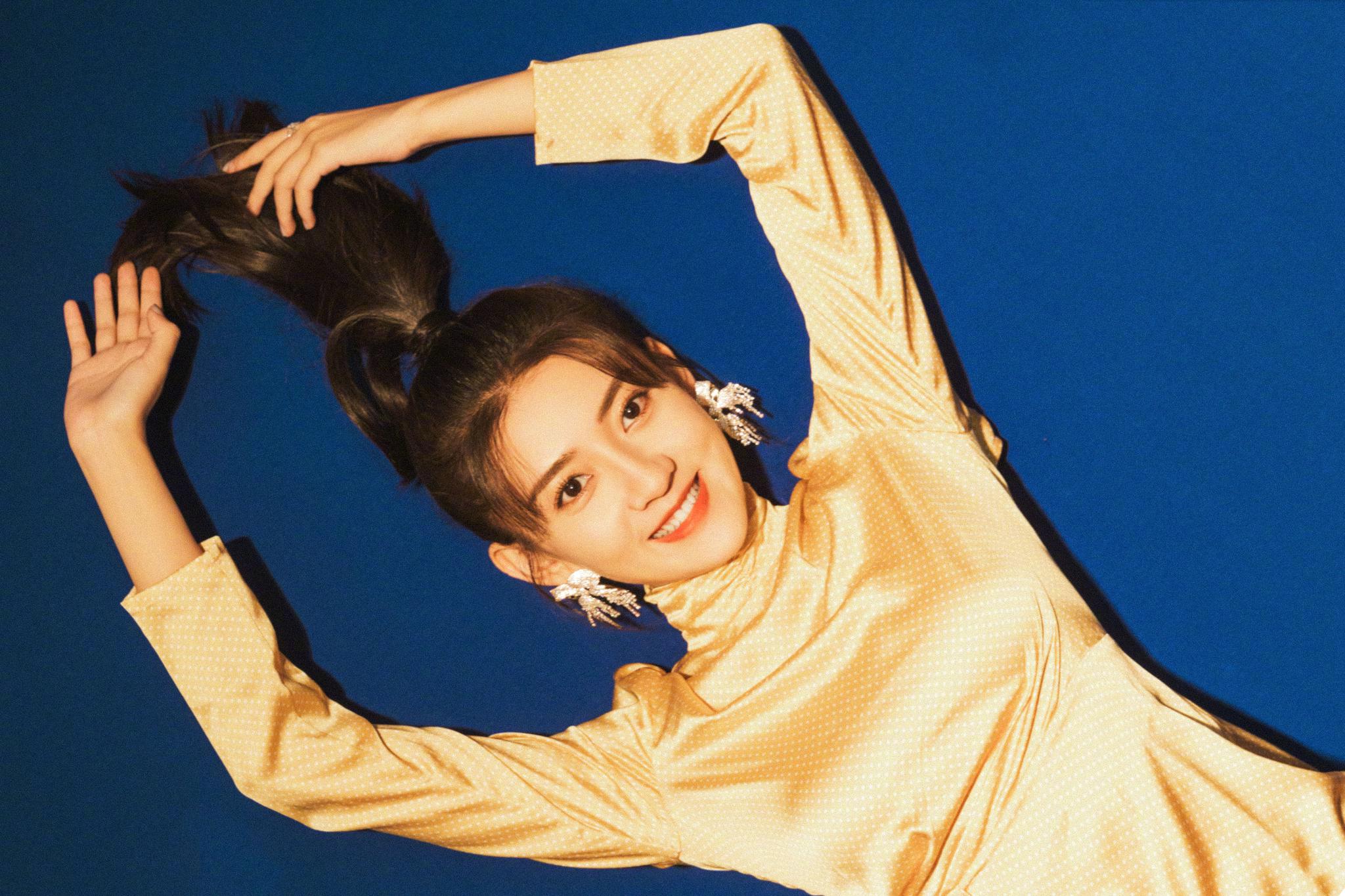 梁洁俏皮马尾金色心形露背连衣裙搭配蝴蝶结闪钻耳饰灵动可爱