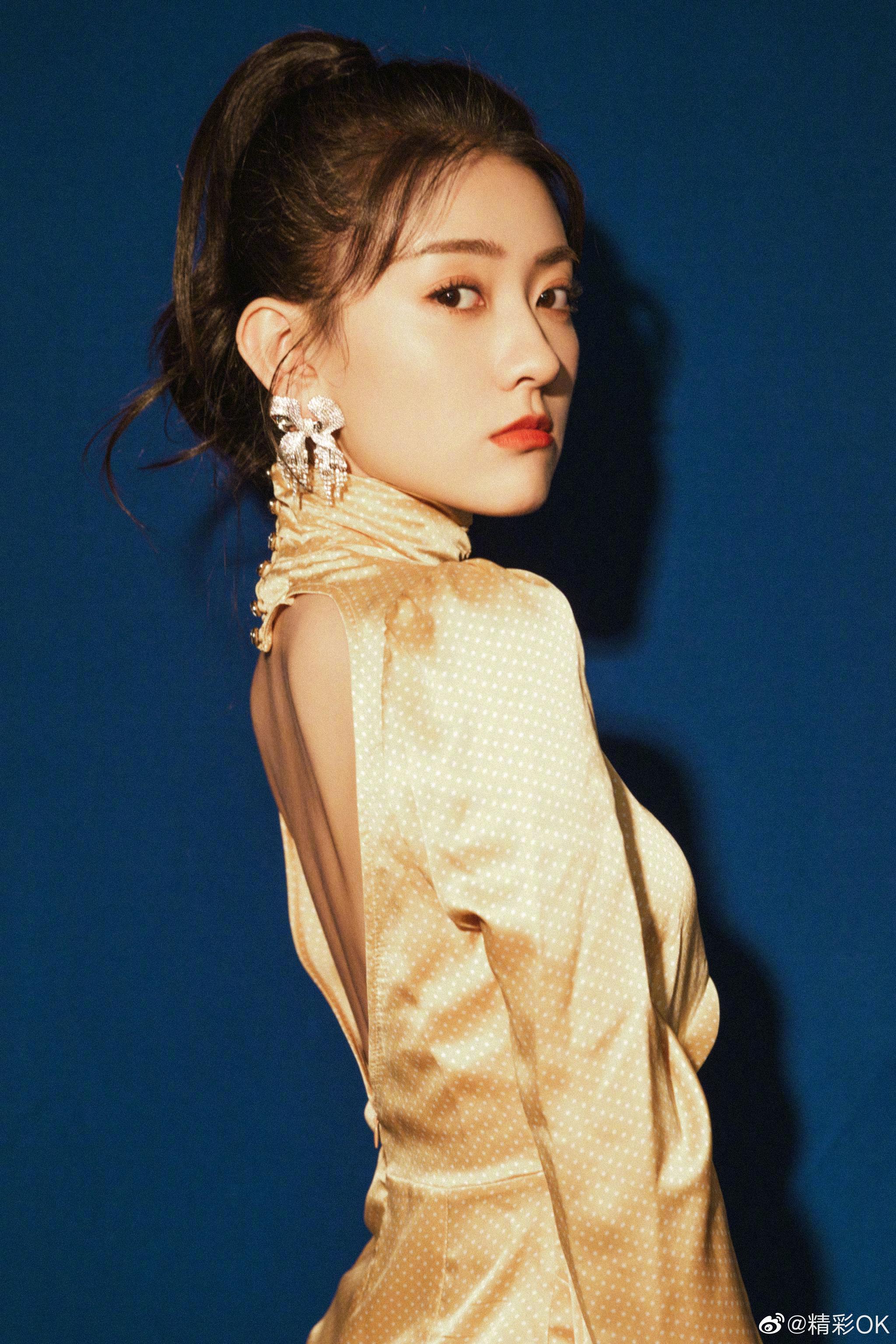 梁洁俏皮马尾金色心形露背连衣裙搭配蝴蝶结闪钻耳饰灵动可爱