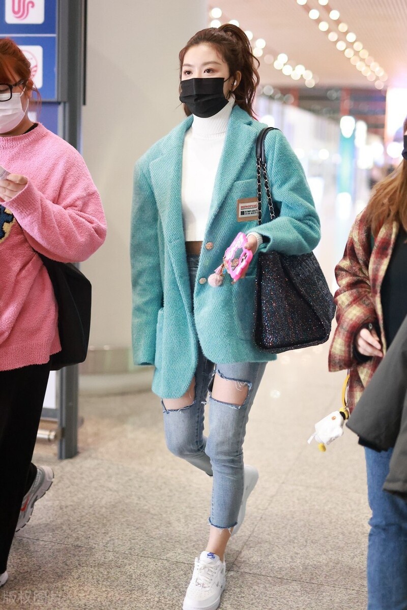 孔雪儿穿搭了一件白色的高领毛衣,外搭的是一件绿色的毛呢西装外套.