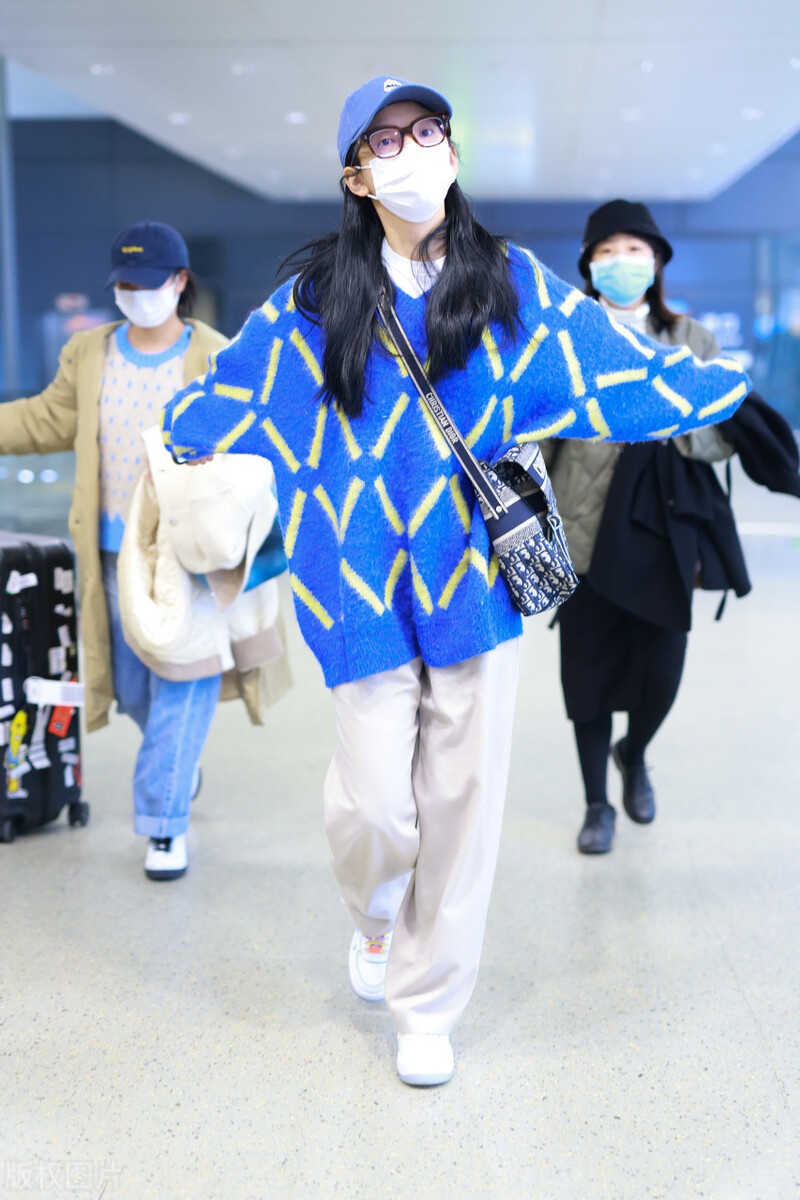 章若楠穿蓝色针织衫搭配休闲裤,头戴蓝色棒球帽简约帅气