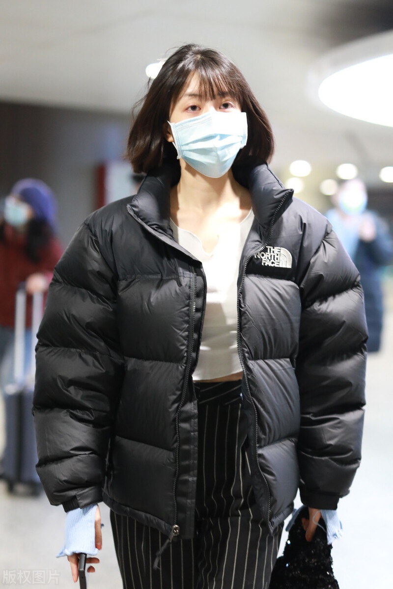 李溪芮黑白穿搭现身机场搭配黑色条纹裤尽显好身材