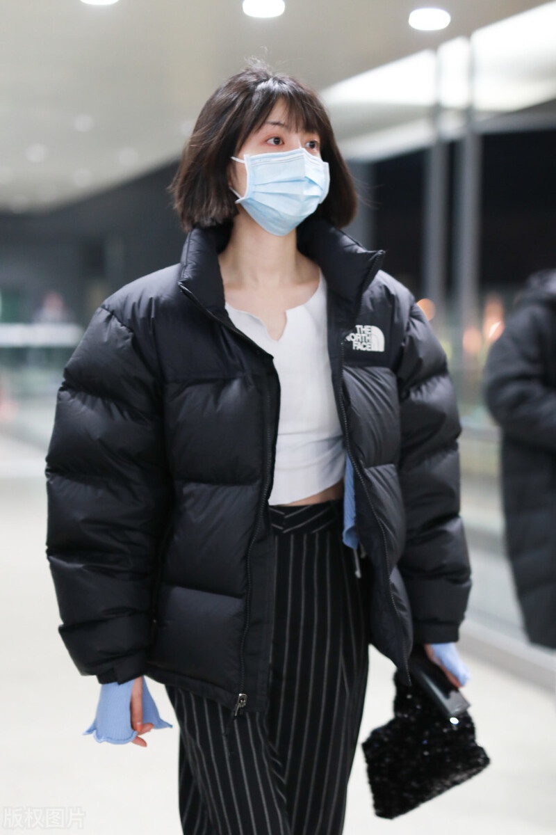 李溪芮黑白穿搭现身机场搭配黑色条纹裤尽显好身材