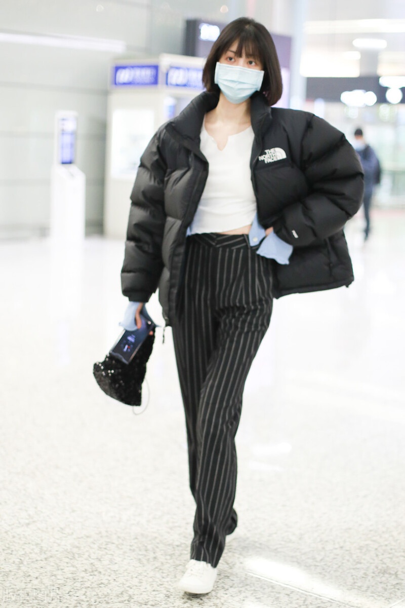 李溪芮黑白穿搭现身机场搭配黑色条纹裤尽显好身材