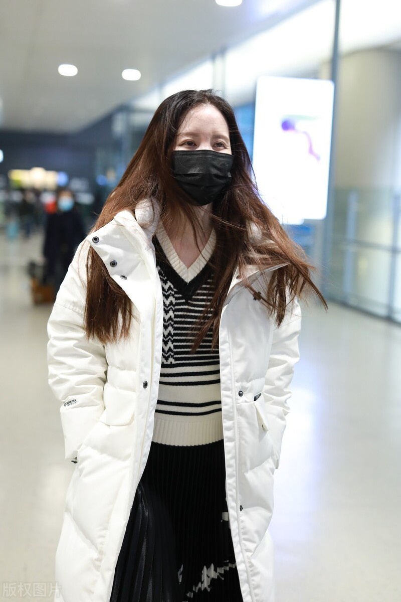 张萌穿长款羽绒服搭配仙鹤裙现身机场长发飘飘女神范