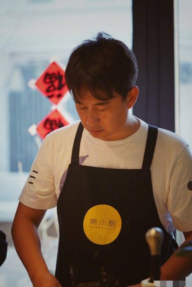围裙和简单t恤的搭配看起来居家好男人气质十足,专注于做菜的黄磊看