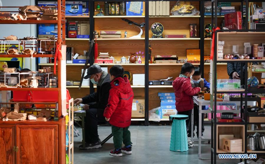 Customers and their children play at a toy shop for the elderly in Beijing, capital of China, Feb. 23, 2021. The toy shop owned by Song Delong, which has about 400 kinds of toys especially for the elderly people, serves not only as a toy shop but a popular leisure and social place for local seniors. (Xinhua/Chen Zhonghao)