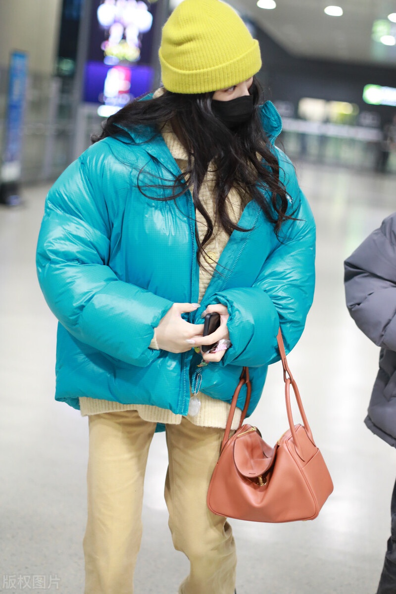 林允穿蓝色羽绒服现身机场,头戴黄色针织帽卖萌很可爱