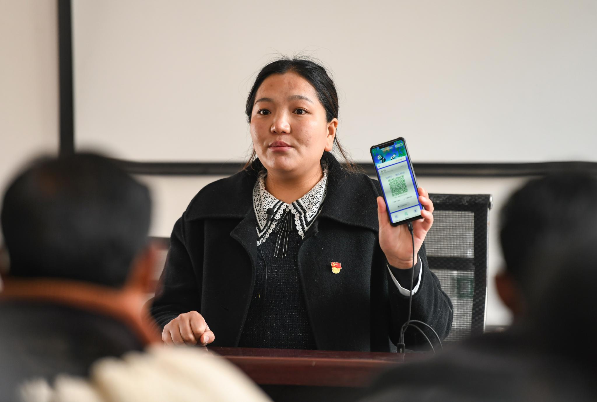 在四川凉山美姑县瓦以村村委会,杨卓玛给村民介绍疫情防控注意事项(3