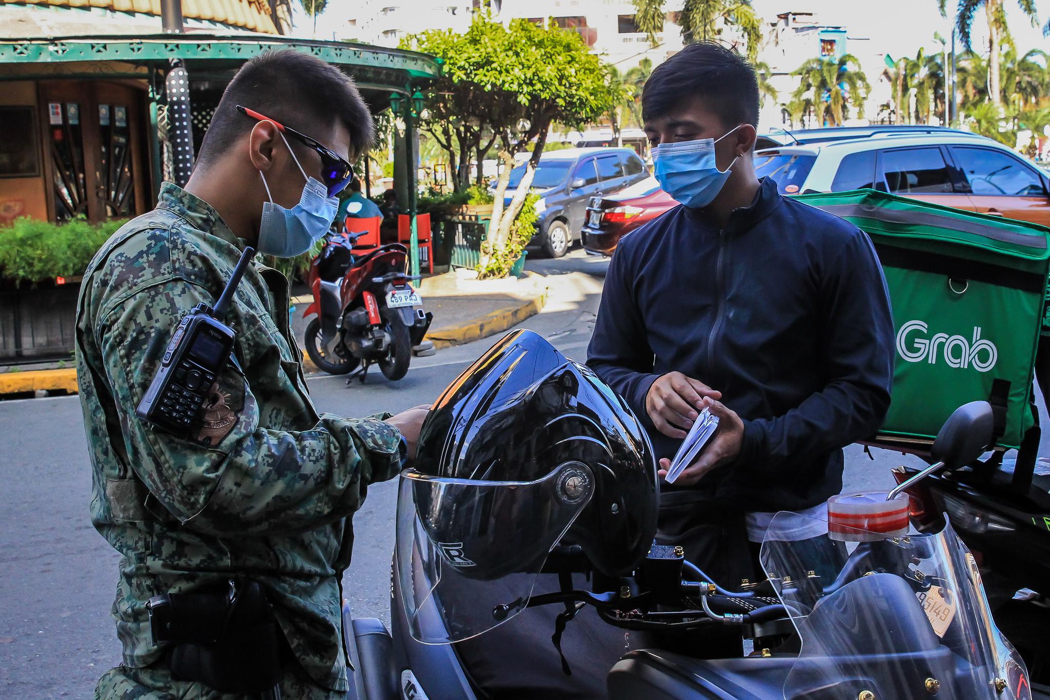 3月10日,警察在菲律宾马尼拉街头一处检查站查看过路人员的信息.