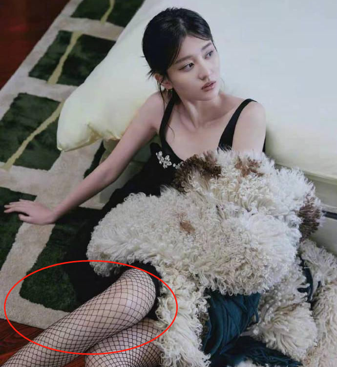 照片中,乔欣穿着一件黑色吊带装,坐地毯上靠在床边,下面还穿着性感的