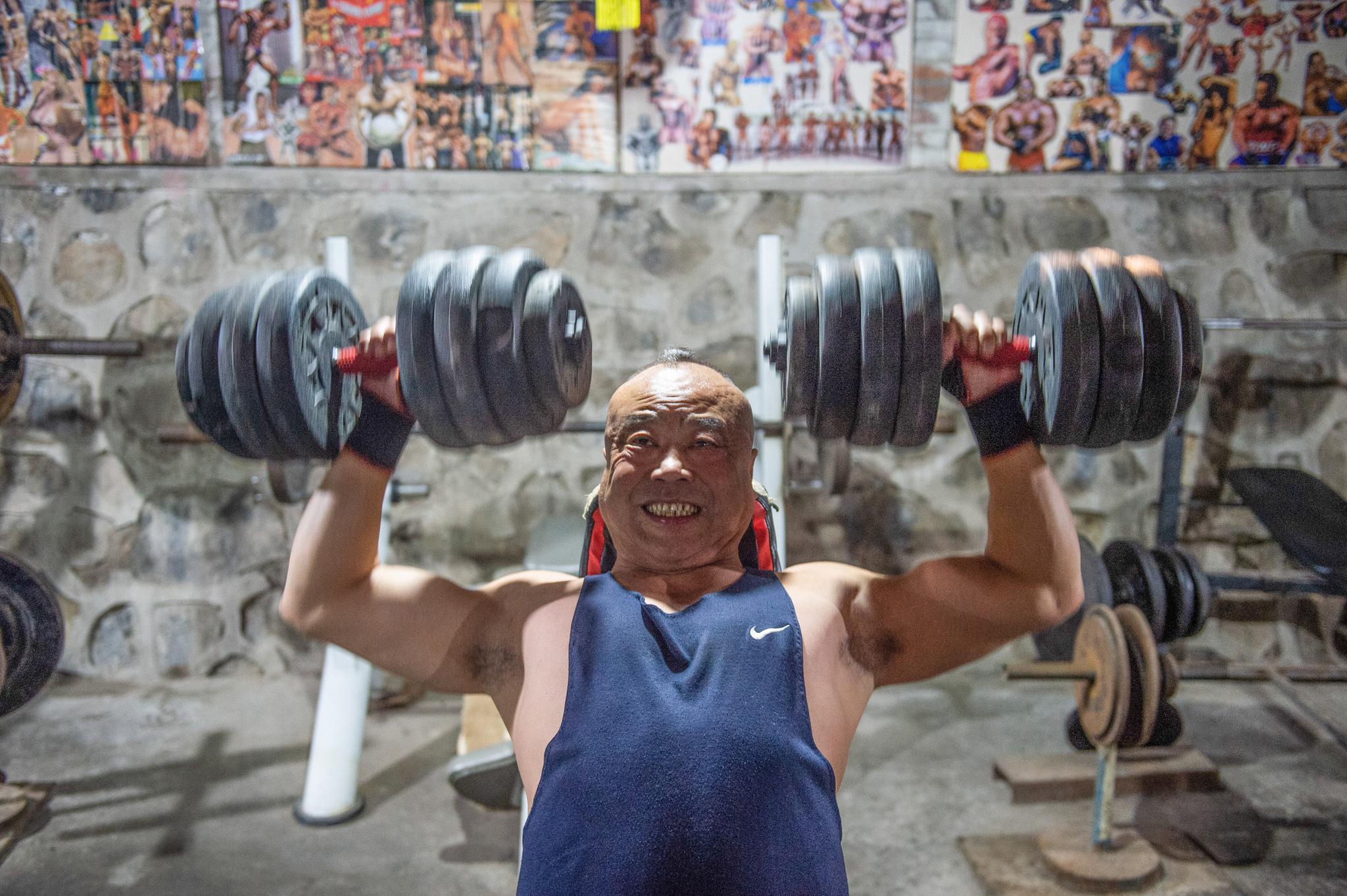 在工业风健身房里"撸铁"的北京大爷