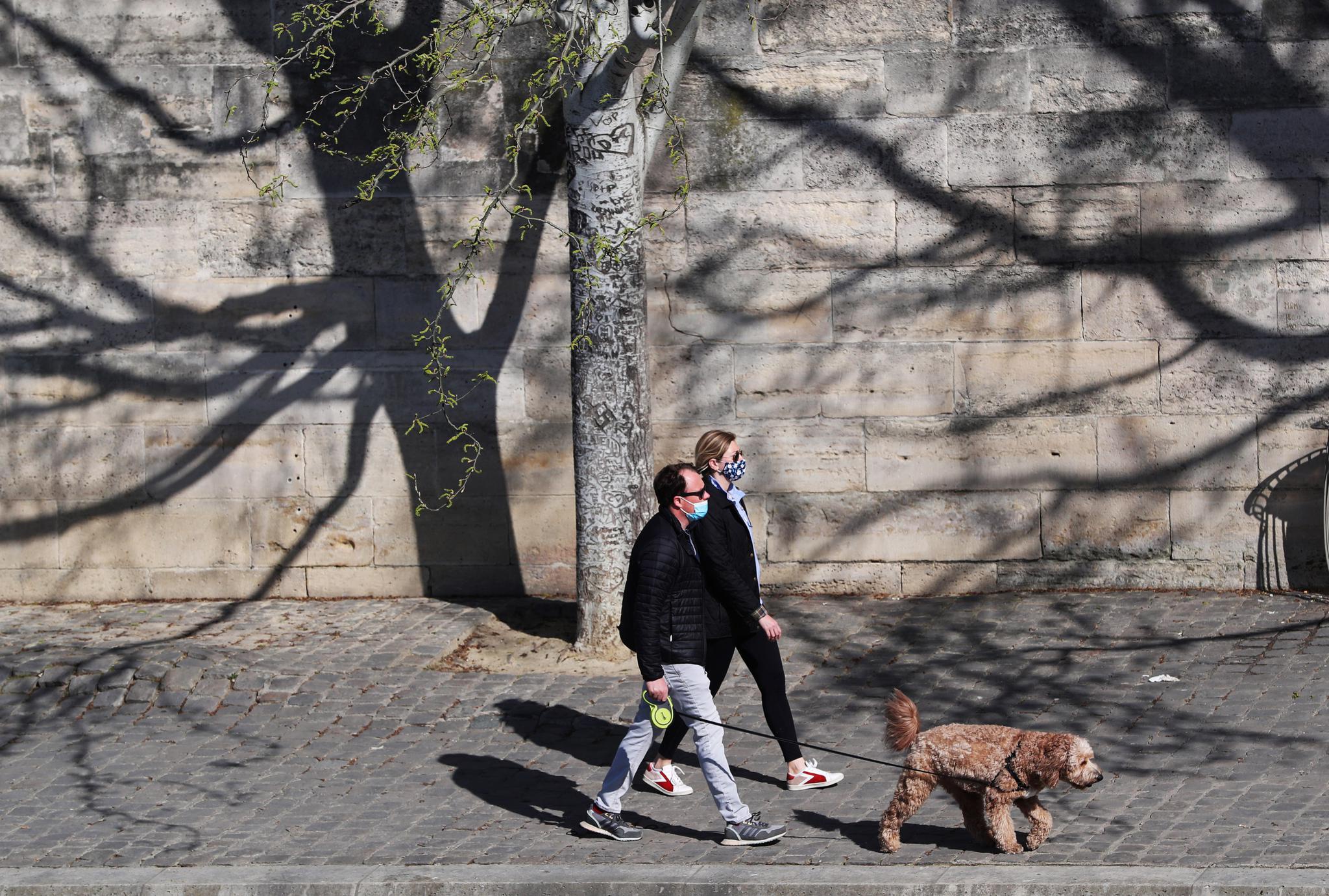 3月24日,一名男子在法国巴黎塞纳河畔晒太阳.新华社记者高静摄